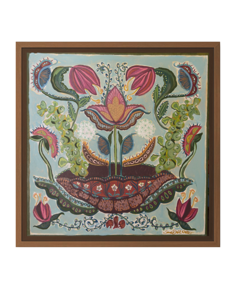 A framed folk art print featuring a stylized floral design with pink flowers, green leaves, and a central lotus motif on a light blue background, enclosed in a brown wooden frame.